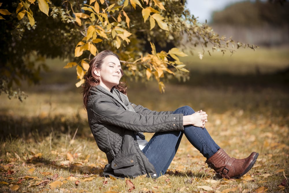 Woman relaxing and resting on the floor on a beautiful autumn sunny day